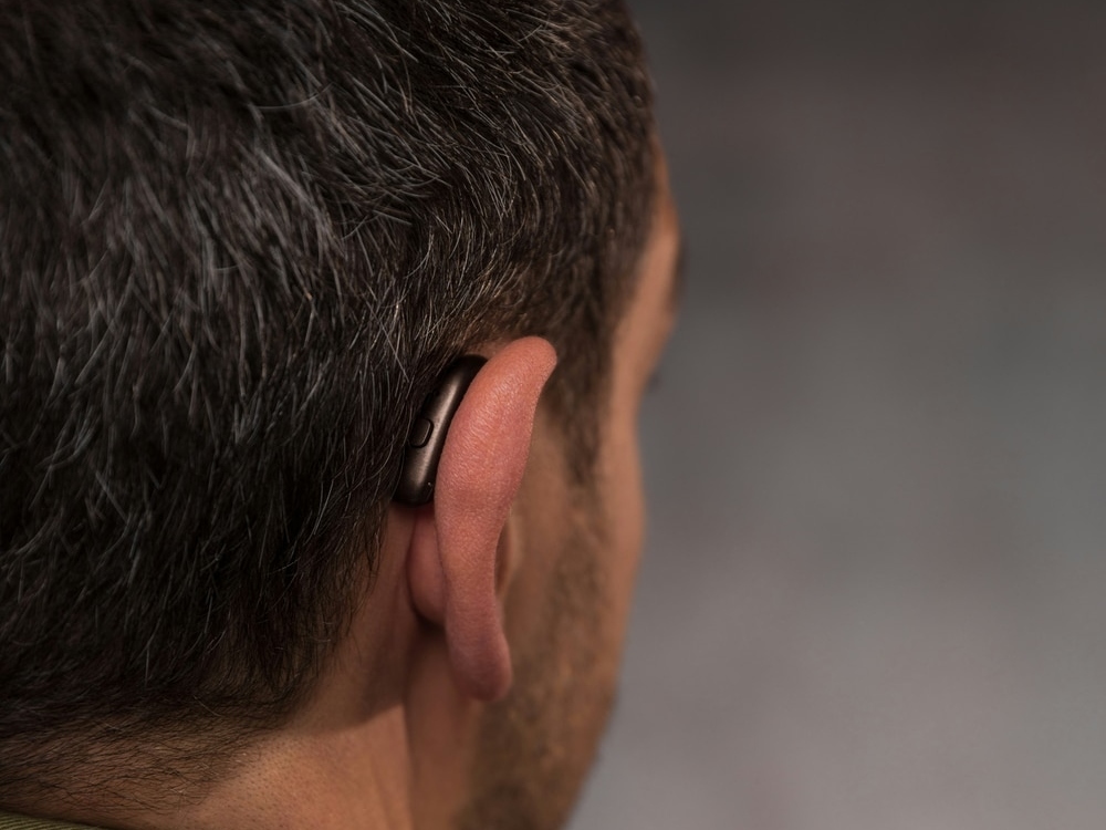 Audiologist fitting a hearing aid using real-ear measurement at Allen Audiology
